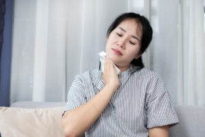 A mature woman experiencing a hot flash at home during menopause.