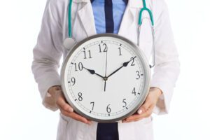 Healthcare Professional with Stethoscope Holding Analog Clock